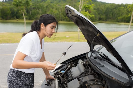 Woman opened the hood Broken car on the side See engines that are damaged or not