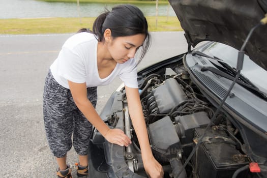 Woman opened the hood Broken car on the side See engines that are damaged or not