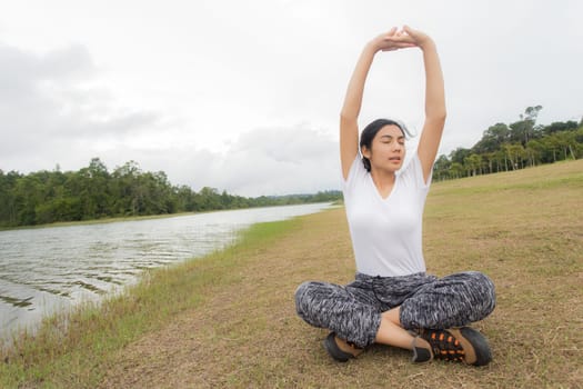 Beautiful smiling young asian woman enjoying yoga, relaxing, feeling alive, breathing fresh air, got freedom from work