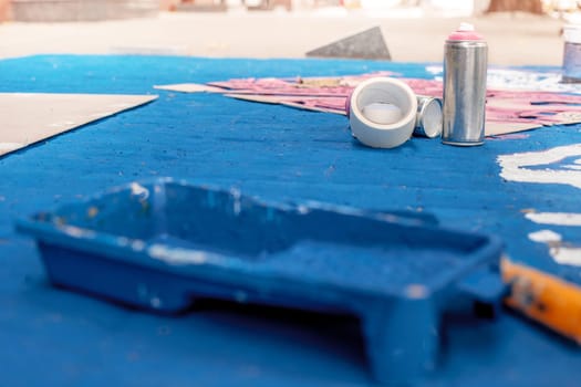 Tools of the street artist and colored pattern on a street of abstract city. Selective focus