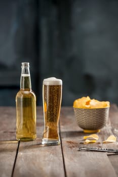 The glass of Beer and potato chips, pistachios isolated on a white