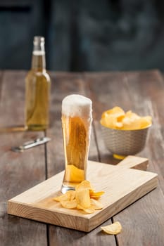 The glass of Beer and potato chips, pistachios isolated on a white