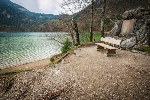 Wide-angle view of a rest area on the Alpsee with bench and memorial plaque to Queen Mother Marie of Bavaria.