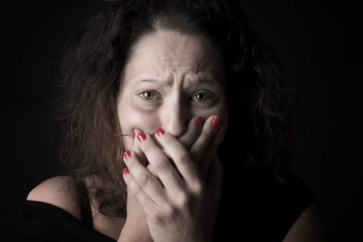 Scared woman covering her mouth, victim of domestic violence