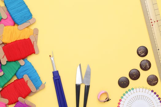 sewing tools, tailoring and fashion concept - close-up on yellow background