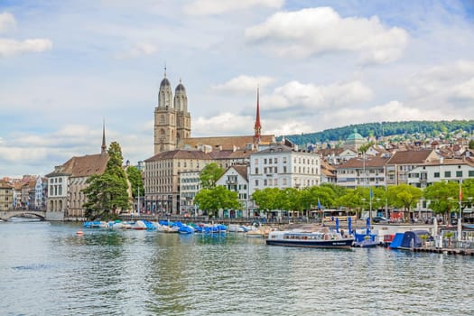 Zurich, Switzerland - June 10, 2017: Minster Grossmunster, view from Quaibrucke bridge, river Limmat in front.