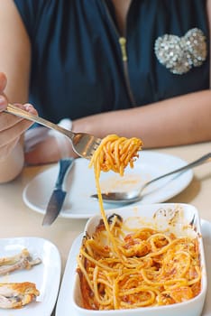 woman eat spaghetti with the great flavors of fresh shrimp and blended in tomato sauce, baked & topped with mozzarella cheese.