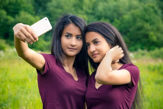 Twins with cell phone take a selfie