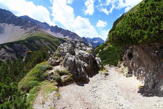 Mountaineering on the Hahntennjoch in Austria. A steep mountain path with large rocks
