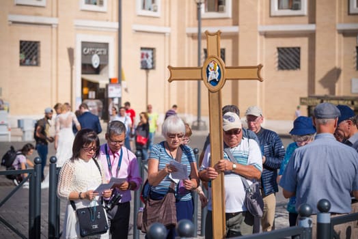 VATICAN CITY, VATICAN - OCTOBER 16, 2016: Group of unknown pilgrims carrying a cross in front of the saint peter's basilica