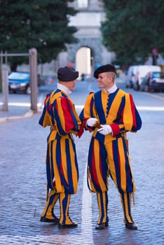 VATICAN CITY, VATICAN - OCTOBER 16, 2016: Famous Swiss Guard guarding the entrance to the Vatican City. The Papal Guard with about 100 men is the world's smallest army.