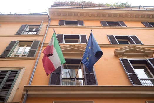 italian national flag and the european flag on a balcony in rome