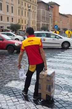 VATICAN CITY, VATICAN - OCTOBER 18, 2016: Unknown DHL courier with large package close to St peter's basilica