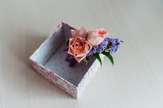 Boutonniere groom with a pink rose, in a box. close-up
