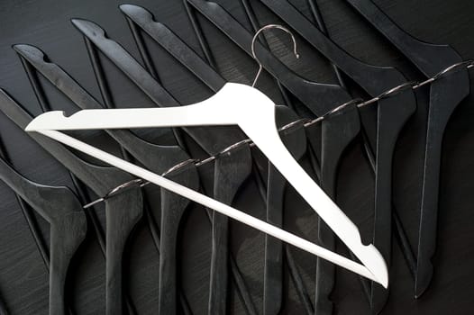 White hanger and a few black hangers, black background, abstract