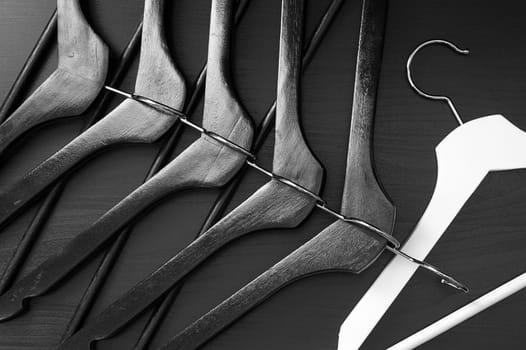White hanger and a few black hangers, black background, abstract