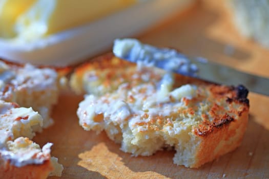 Buttering toast with bright morning light