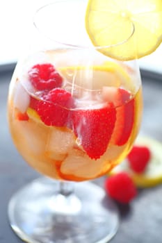 White wine with ice, lemon, strawberries and raspberries