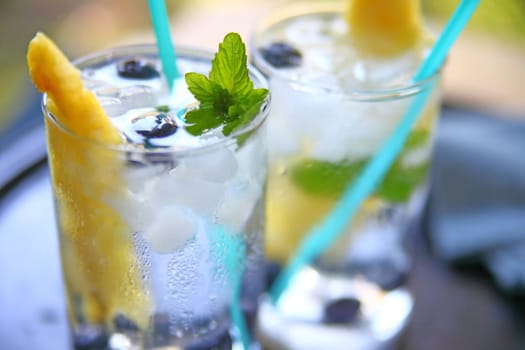 Glasses of white wine with fresh pineapple, blueberries and mint with crushed ice
