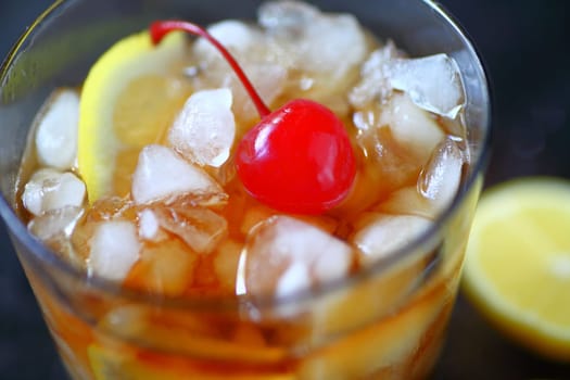 Whiskey sour cocktail with lemon, crushed ice and a cherry