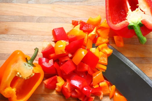 Overhead of red and orange bell peppers, chopped and halves with copy space