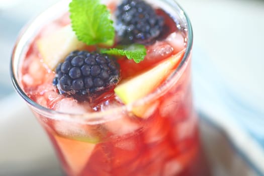 Closeup of icy wine cocktail with fresh apple and blackberries