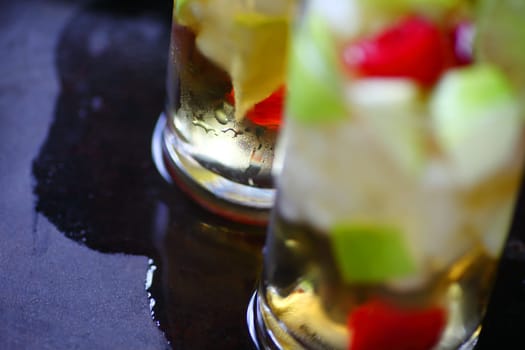 Cold wine cocktails with apple and fresh berries on a wet tray