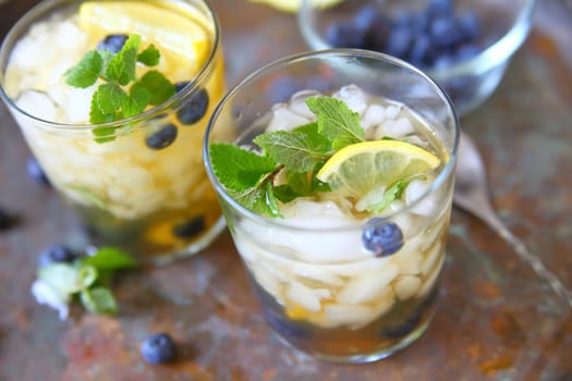 Glasses of green tea with crushed ice, lemon, blueberries and mint