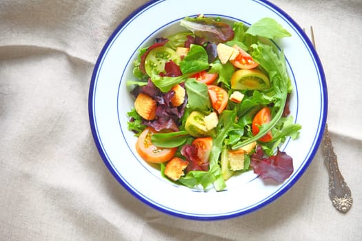 Salad with miniature heirloom tomatoes, mixed young lettuces and croutons with copy space