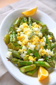 Asparagus with chopped boiled egg and lemon wedges from overhead