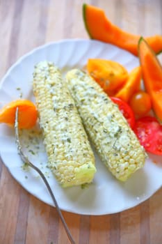 Corn on the cob with cilantro mayonnaise, tomatoes and cantaloupe