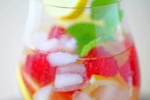 Glass of wine with ice, lemon, raspberries and mint