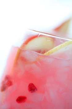 Closeup of blush wine cocktail with fresh pear and pomegranate seeds with copy space