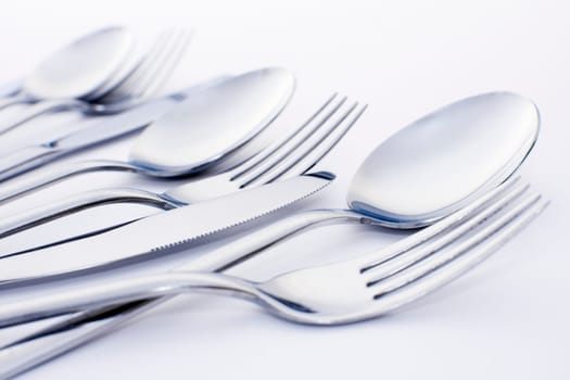Forks spoons and knifes are on white background.