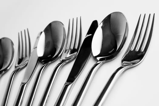 Forks spoons and knifes are on white background.