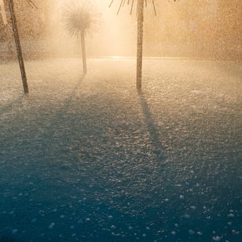 Fountains and splashes of water in the backlight of the sun