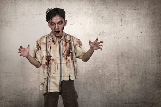 Portrait of asian zombie man with blood standing over grunge background