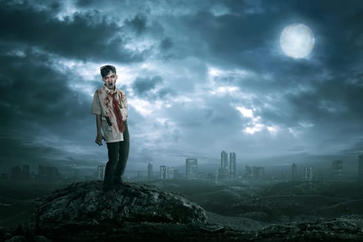 Spooky asian zombie man with blood in the body standing against dark city background