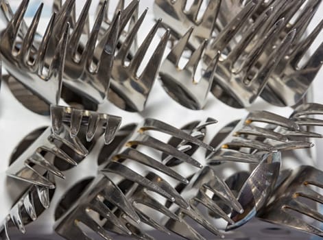 many forks in box of dishwasher. Top view