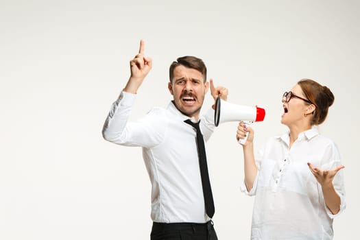 Successful business couple at the office on white background. Listening, Megaphone, Shouting concept.