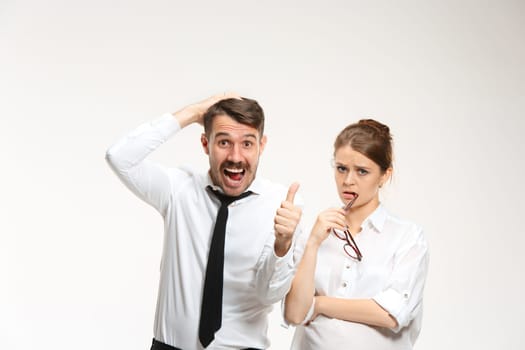 Successful business couple at the office looking at camera on white background with different emotions