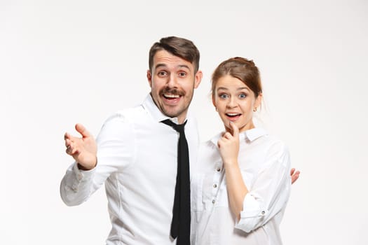 Successful surprised business couple at the office looking at camera on white background
