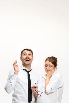 Successful surprised business couple at the office looking up on white background