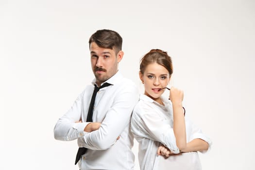 Successful business couple at the office looking at camera on white background