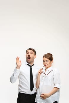 Successful surprised business couple at the office looking up on white background