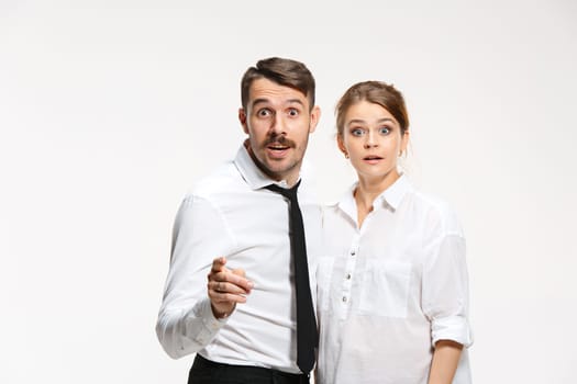 Successful surprised business couple at the office looking at camera on white background