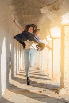 Beautiful and happy young girl jumping outdoors