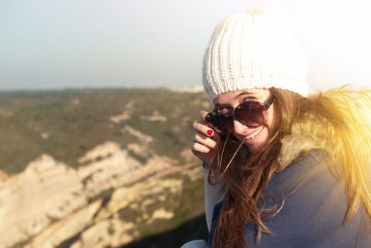 Beautiful happy young girl posing outdoors with sunglasses