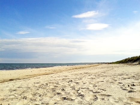 sandy beach of marielyst, denmark with ocean baltic sea and blue sky