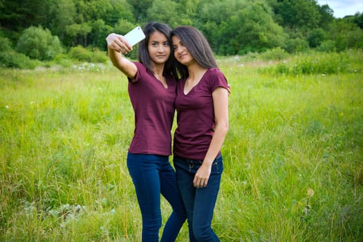 Twins with cell phone take a selfie